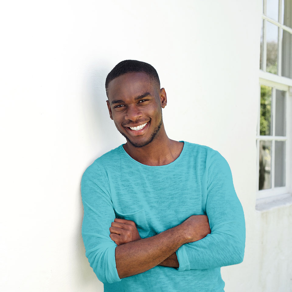 Smiling young man leaning against a wall