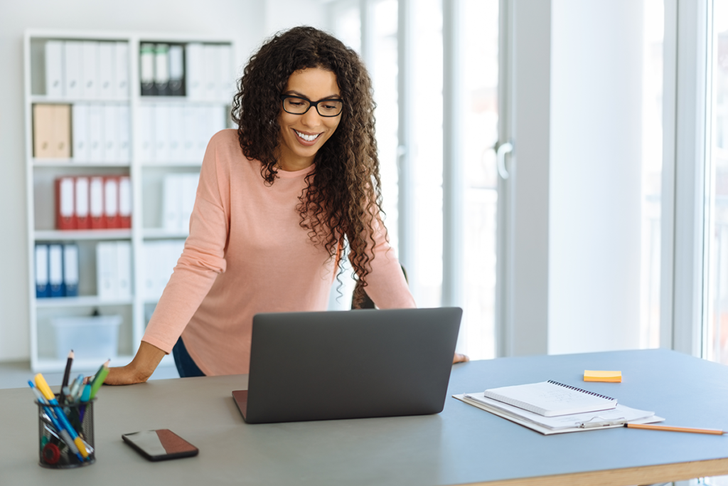 Business owner in her shop looking up loans for self-employed people on her laptop