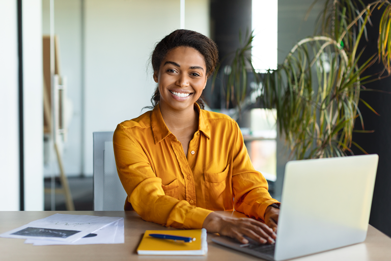 happy woman at desk on laptop