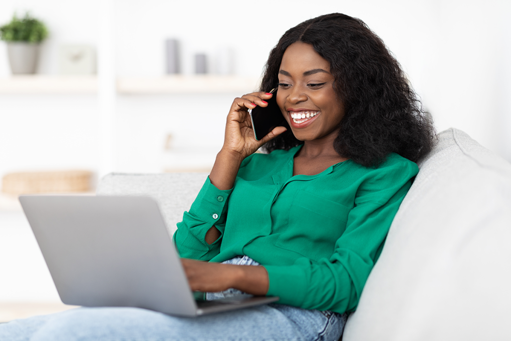 woman on laptop and phone looking up loans