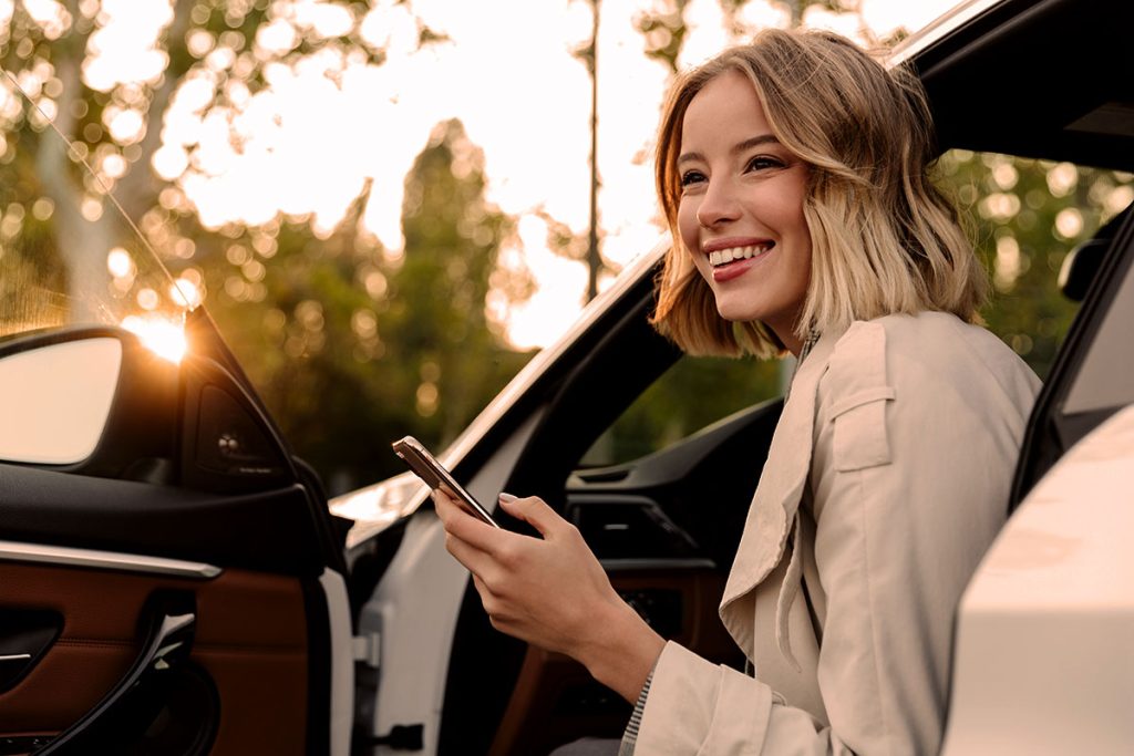 beautiful woman sitting in car and using cellphone