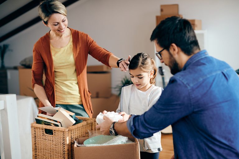 Happy family unpacking their belongings at their new home.