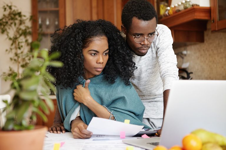 a woman and a man looking at laptop