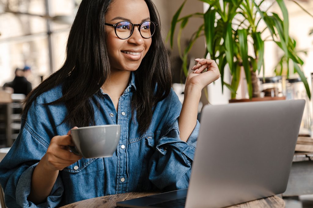 smiling young woman looking at laptop